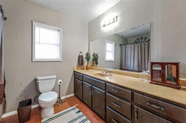 a bathroom with a granite countertop toilet sink and mirror