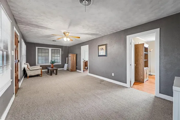 a living room with furniture and a ceiling fan