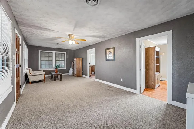 a living room with furniture and a ceiling fan