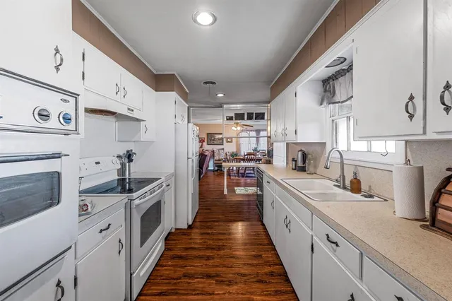 a large kitchen with stainless steel appliances lots of counter space and wooden floor