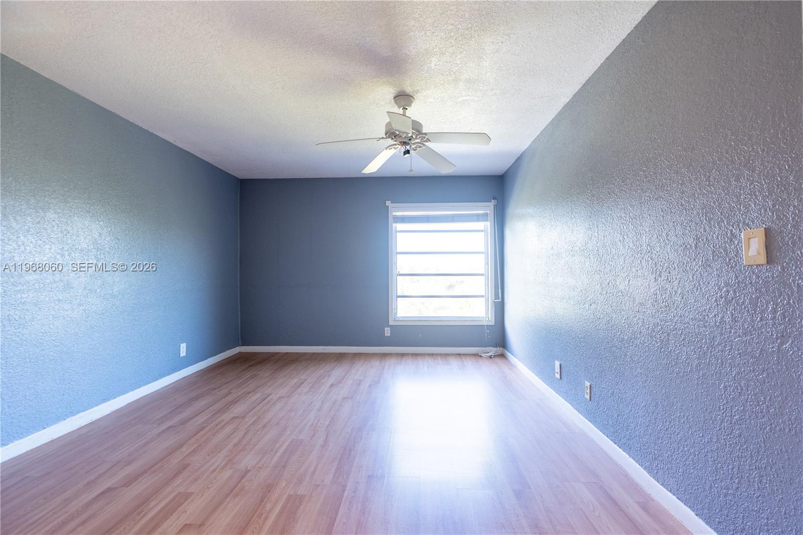 430 Commodore Drive, Unit 314 Plantation, FL 33325 - Photo 34 of 54 an empty room with wooden floor ceiling fan and windows