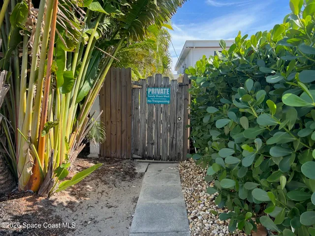an empty room with wooden floor and a kitchen
