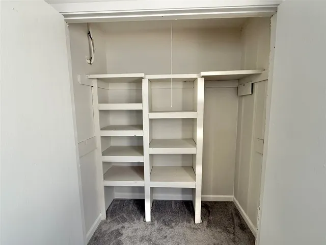 a bedroom with a bed and a mirror on a dresser