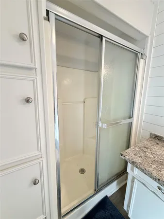 a bathroom with a granite countertop shower and a mirror