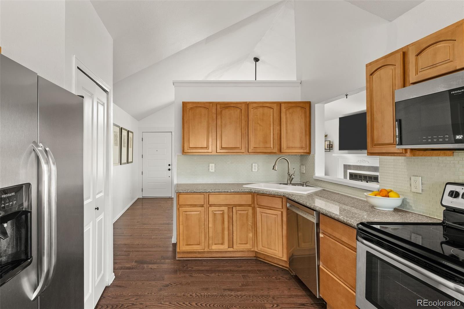 6404 Raleigh Street Arvada, CO 80003 - Photo 13 of 50 a kitchen with stainless steel appliances a stove microwave and refrigerator