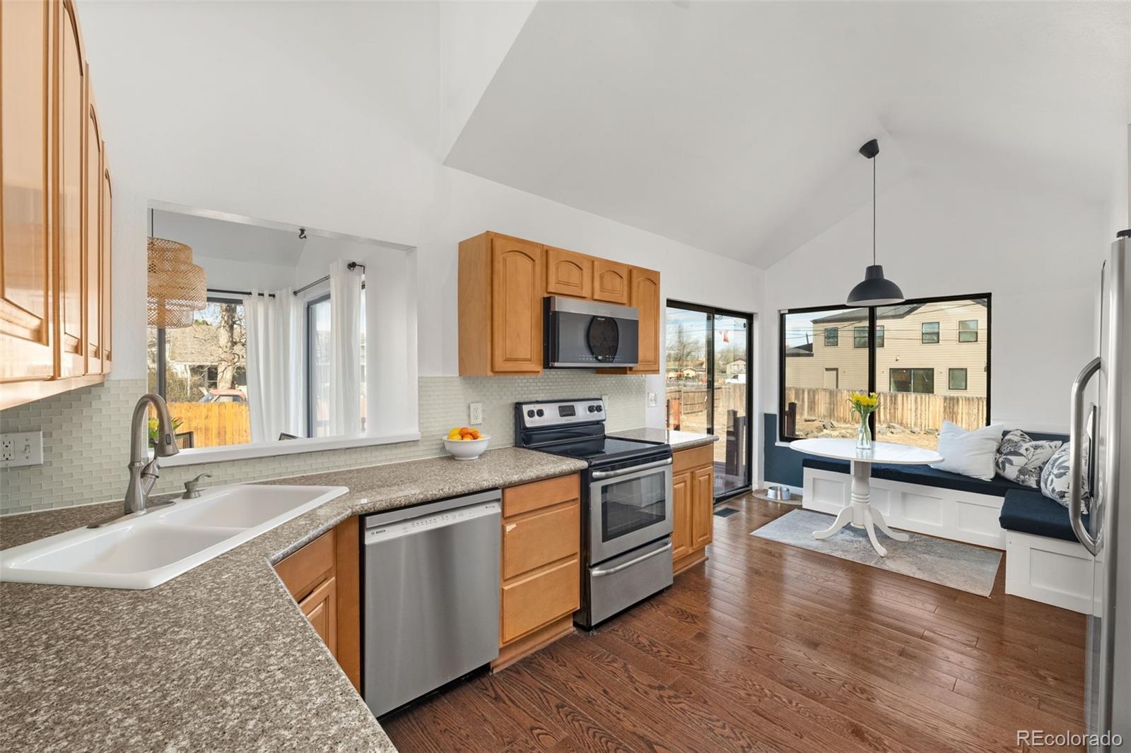 6404 Raleigh Street Arvada, CO 80003 - Photo 14 of 50 a kitchen with stainless steel appliances granite countertop a sink stove and refrigerator