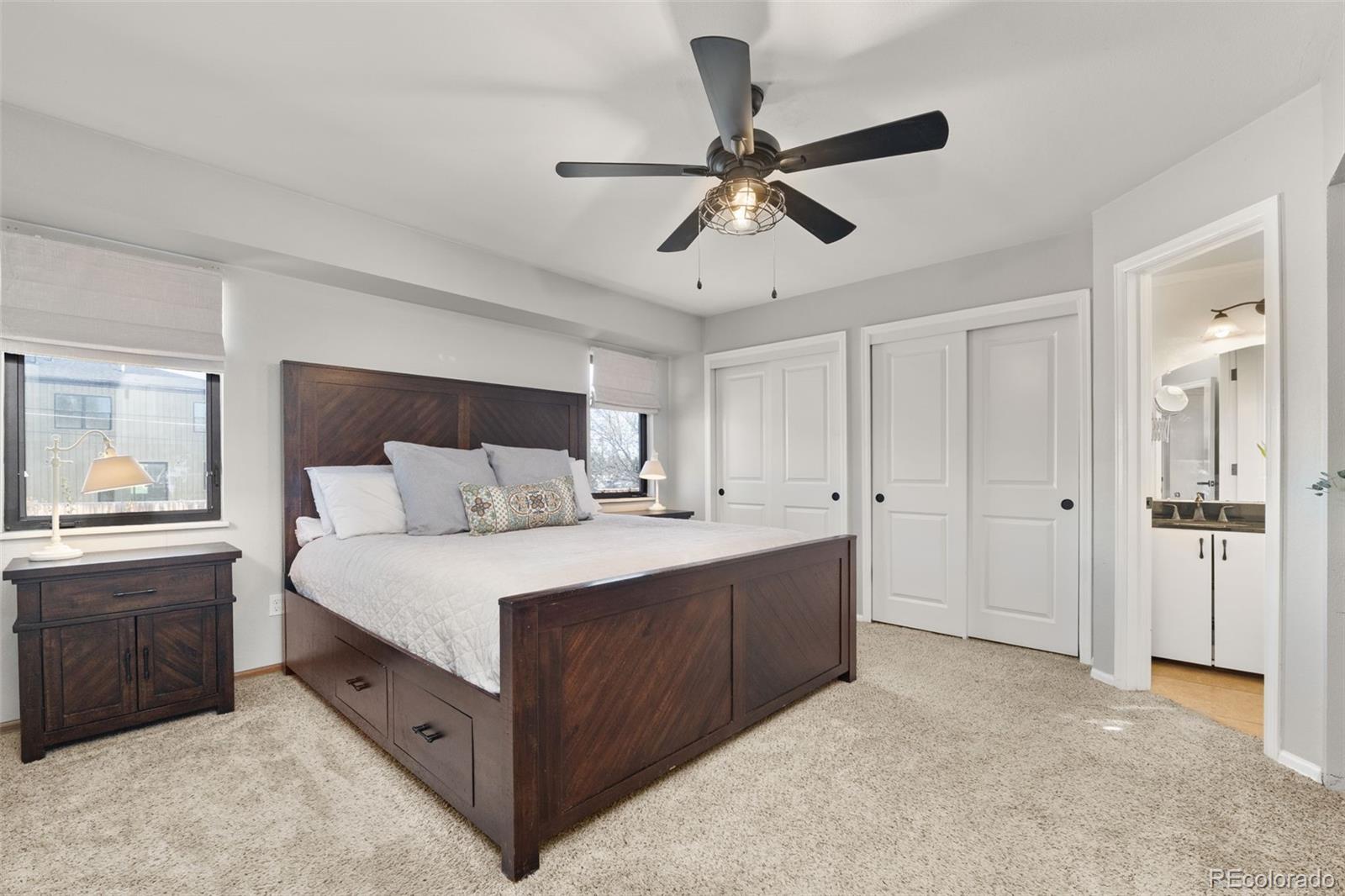 6404 Raleigh Street Arvada, CO 80003 - Photo 19 of 50 a spacious bedroom with a bed and a chandelier