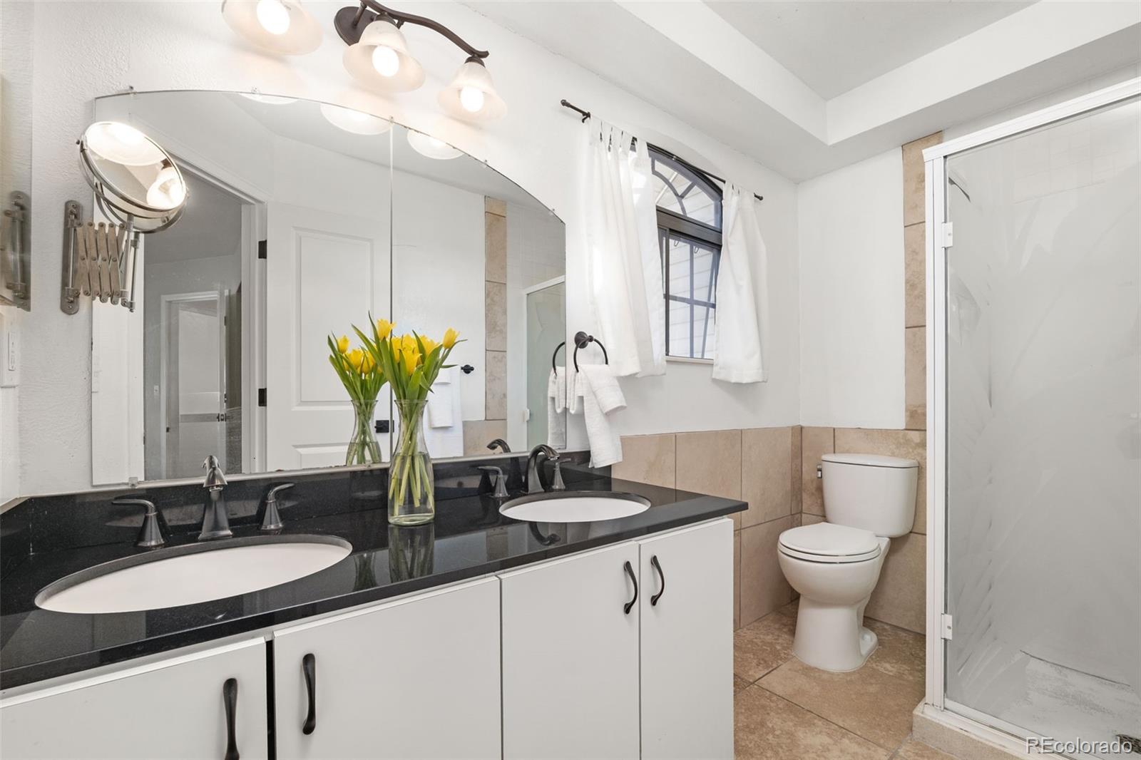 6404 Raleigh Street Arvada, CO 80003 - Photo 23 of 50 a bathroom with a double vanity sink and a mirror