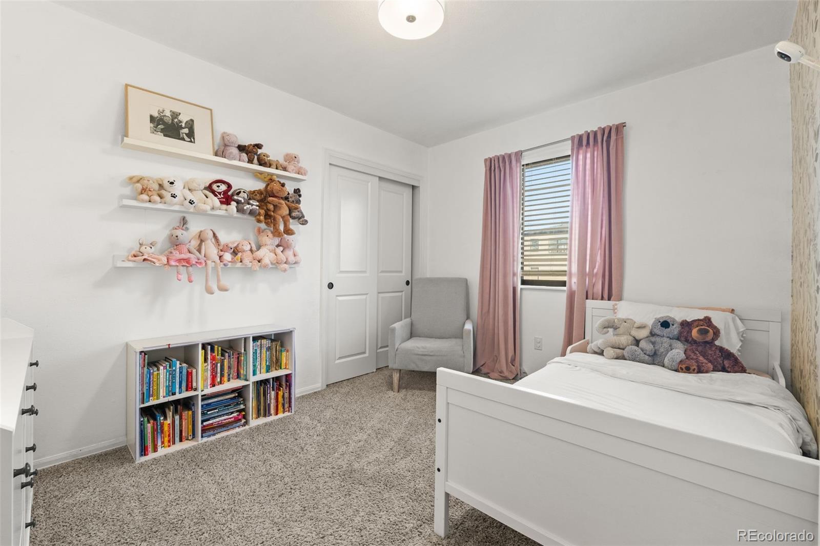 6404 Raleigh Street Arvada, CO 80003 - Photo 25 of 50 a bedroom with a bed and a book shelf