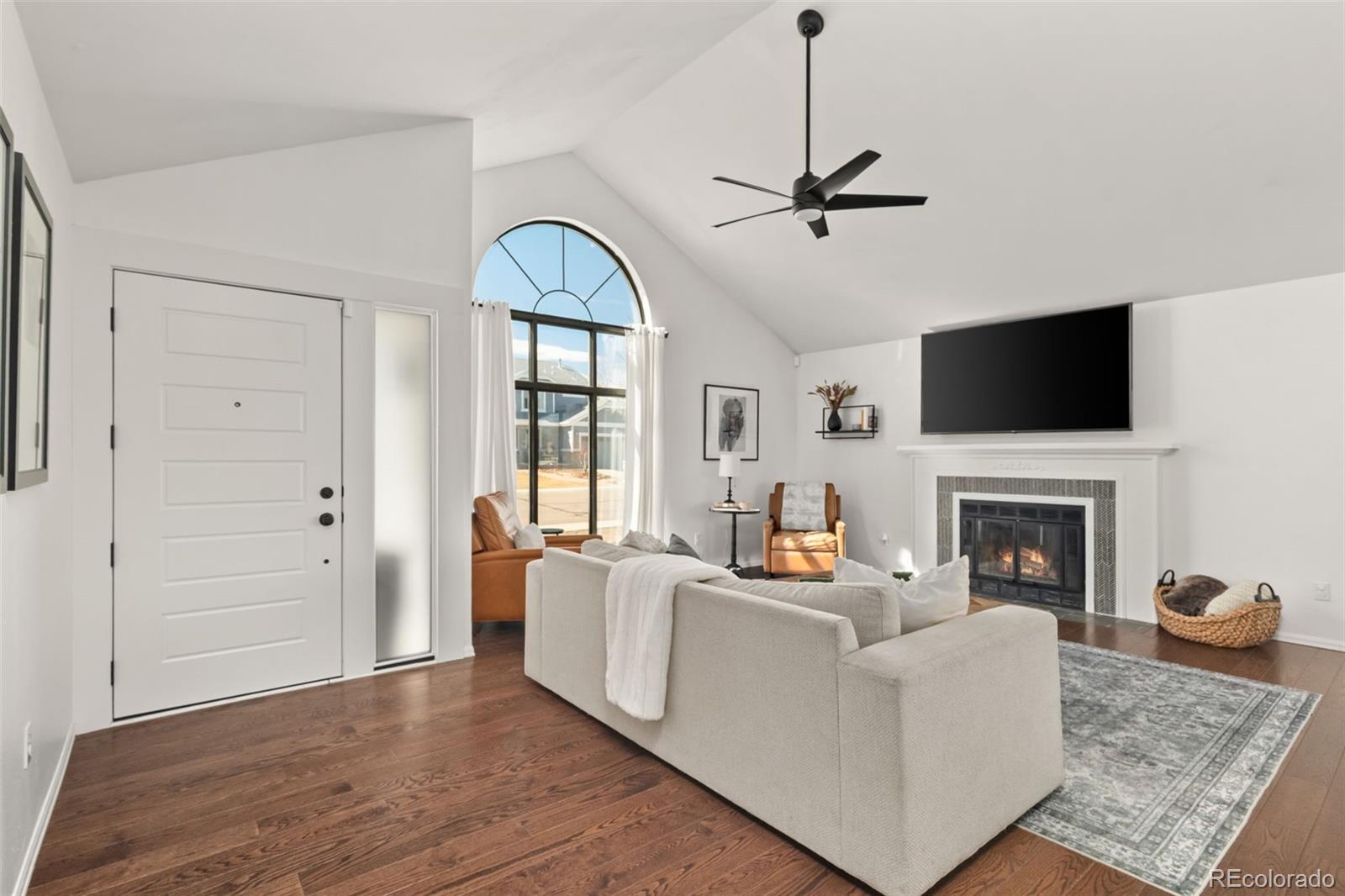 6404 Raleigh Street Arvada, CO 80003 - Photo 4 of 50 a living room with furniture a fireplace and a flat screen tv