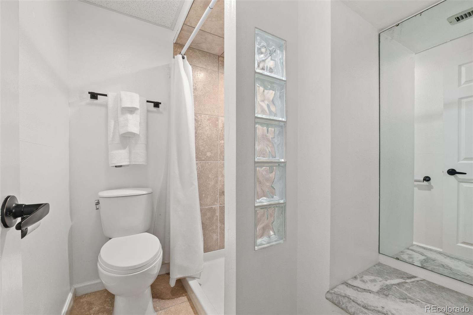 6404 Raleigh Street Arvada, CO 80003 - Photo 45 of 50 a bathroom with a toilet sink and shower