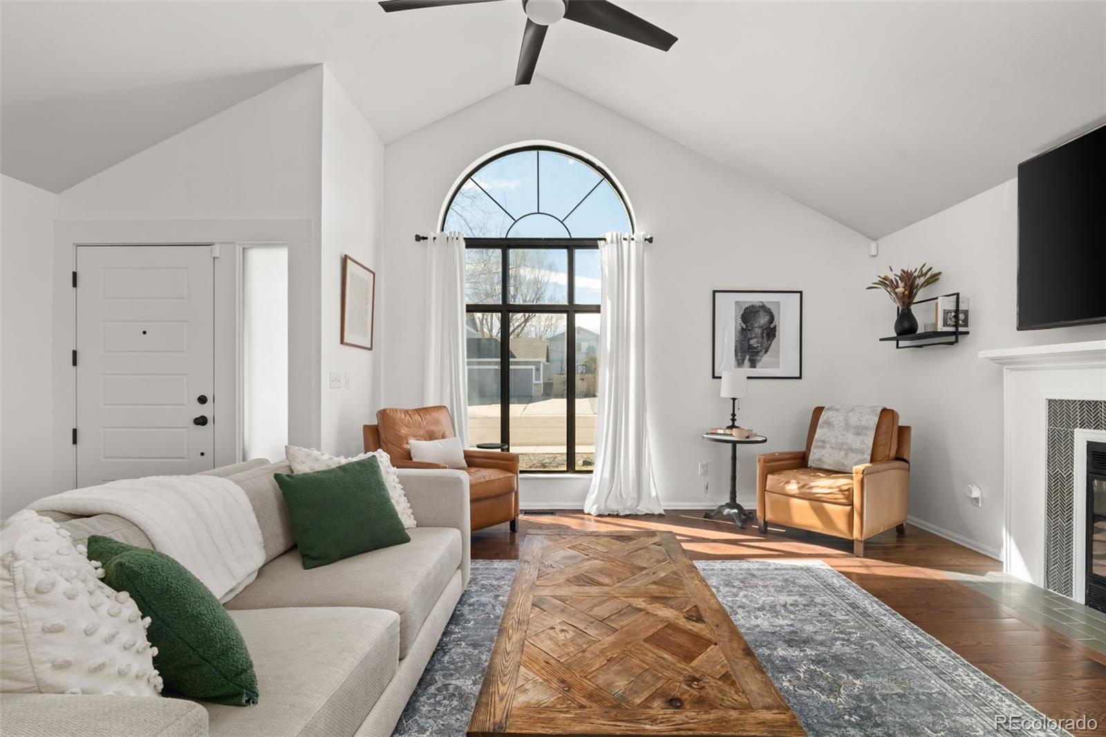 6404 Raleigh Street Arvada, CO 80003 - Photo 5 of 50 a living room with furniture and a fireplace
