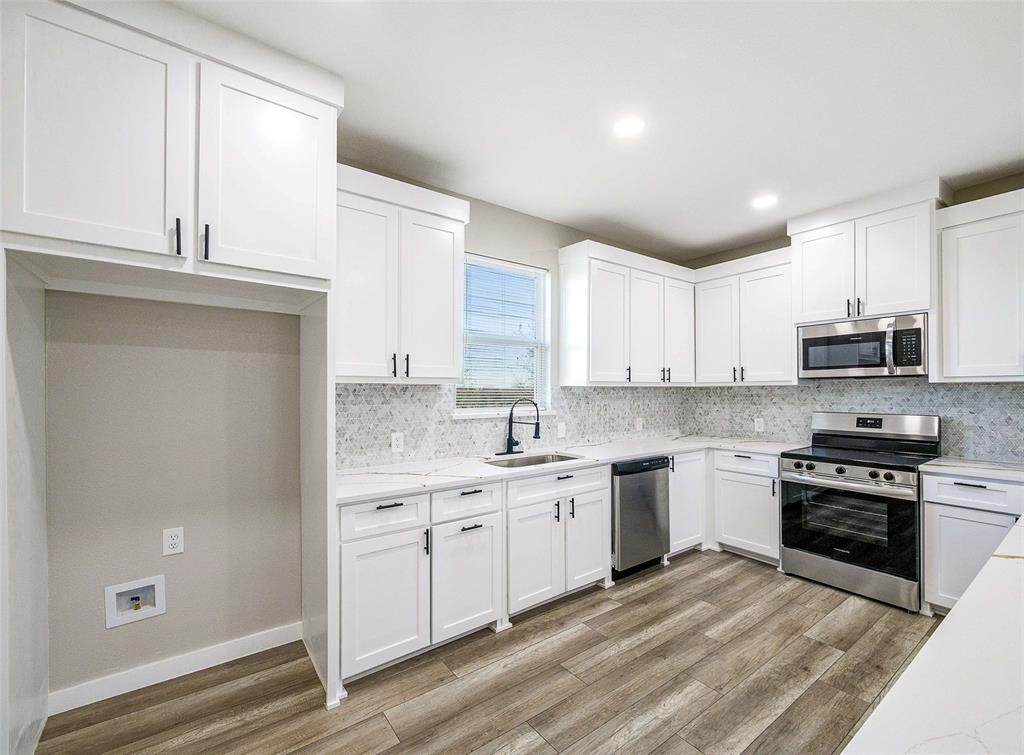 1061 Zmolek Road Ennis, TX 75119 - Photo 8 of 40 a kitchen with stainless steel appliances granite countertop a stove a sink and a refrigerator
