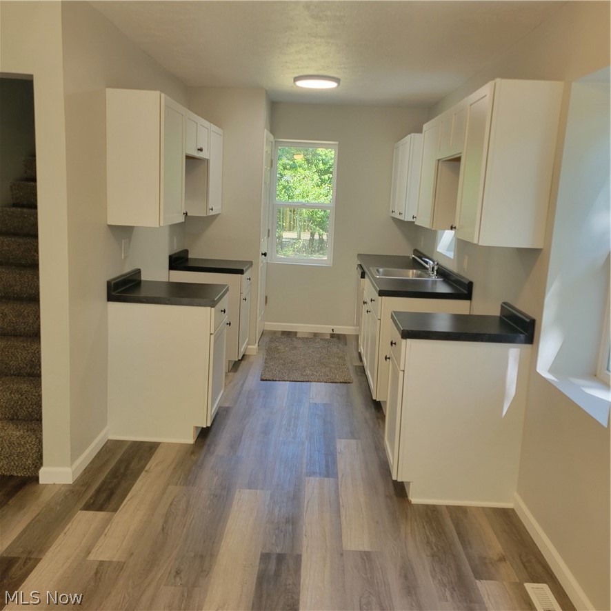 1500 Warner Road Southeast Canton, OH 44707 - Photo 2 of 21 Kitchen featuring white cabinetry, sink, and light wood-type flooring