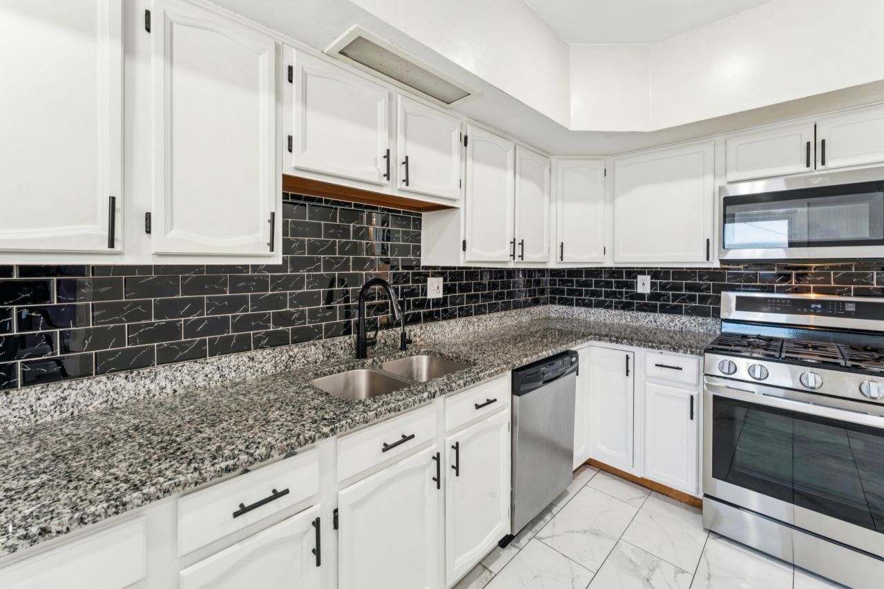 2547 Davisson Street River Grove, IL 60171 - Photo 7 of 31 a kitchen with granite countertop white cabinets and stainless steel appliances