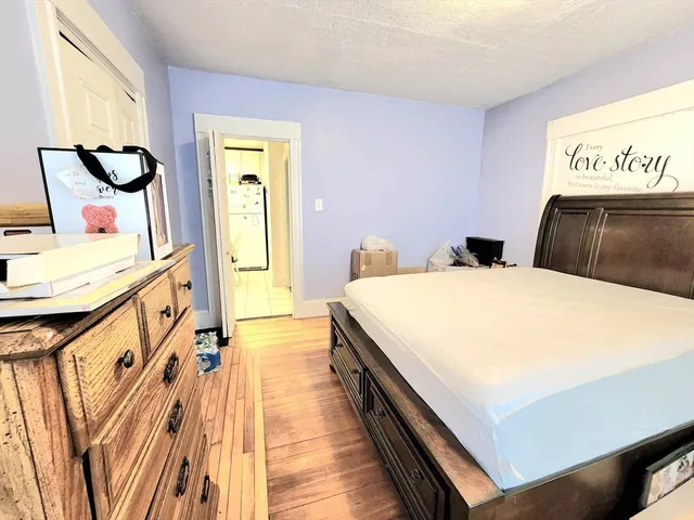 a bedroom with a bed and dresser with mirror
