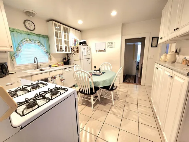 a kitchen with stainless steel appliances a sink a stove a refrigerator and cabinets