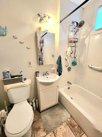a white toilet sitting next to a bath tub