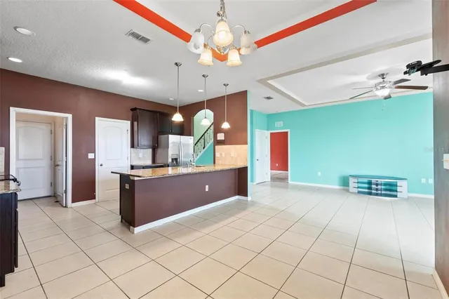 a open kitchen with stainless steel appliances kitchen island granite countertop a refrigerator and a sink