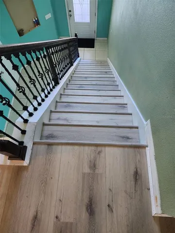 a view of a hallway with wooden floor and staircase