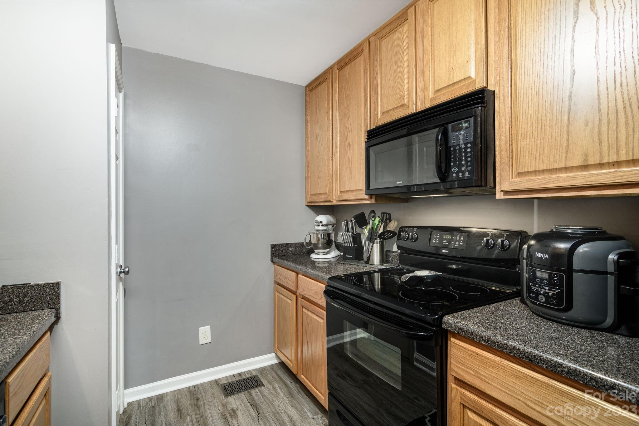 615 Raphael Place Charlotte, NC 28205 - Photo 8 of 20 a kitchen with stainless steel appliances granite countertop a stove microwave and sink