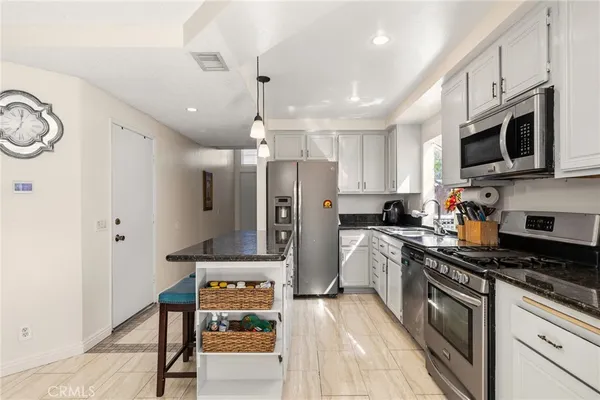 a dining room with furniture a chandelier and wooden floor