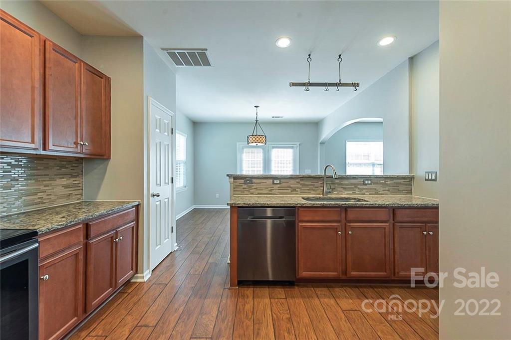 705 Jones Branch Road Fort Mill, SC 29715 - Photo 4 of 18 a kitchen with kitchen island granite countertop wooden floors and stainless steel appliances