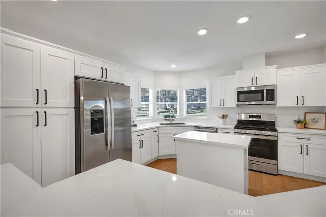 a kitchen with stainless steel appliances granite countertop a refrigerator sink and stove