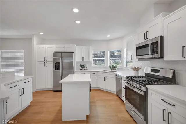 a kitchen with stainless steel appliances a refrigerator stove microwave and cabinets