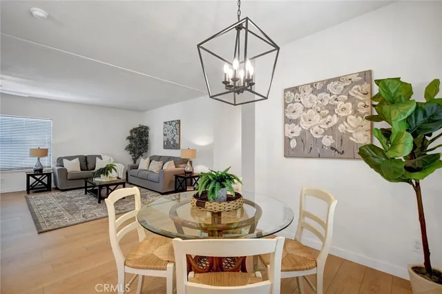 a dining room with furniture a chandelier and wooden floor