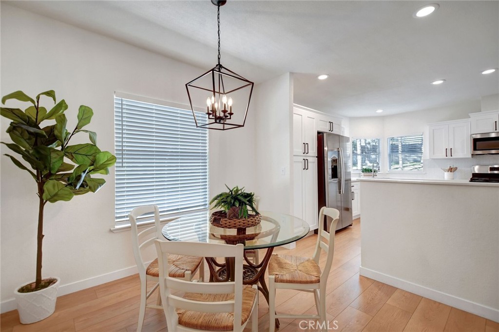 8651 Foothill Boulevard, Unit 42 Rancho Cucamonga, CA 91730 - Photo 19 of 39 a dining room filled chandelier and wooden floor