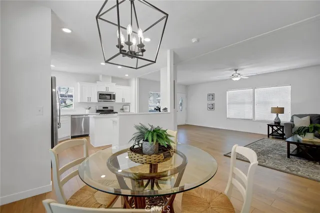 a view of a dining room with furniture a kitchen and chandelier