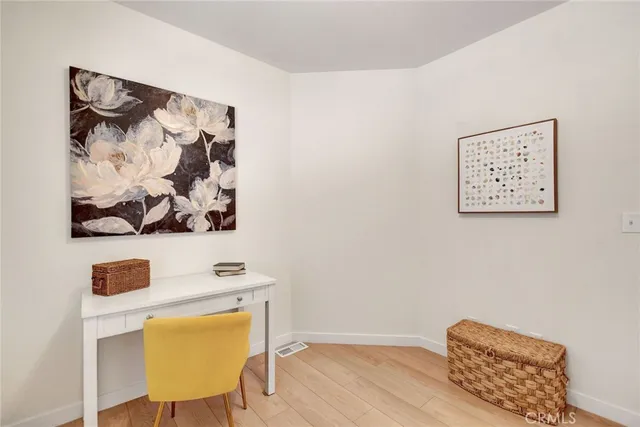 a view of a workspace with furniture and wooden floor
