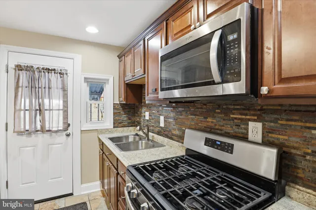 a kitchen with stainless steel appliances granite countertop a sink stove and microwave