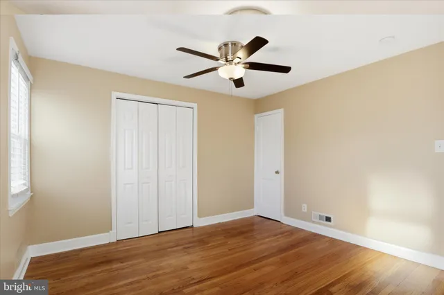 a view of empty room with wooden floor