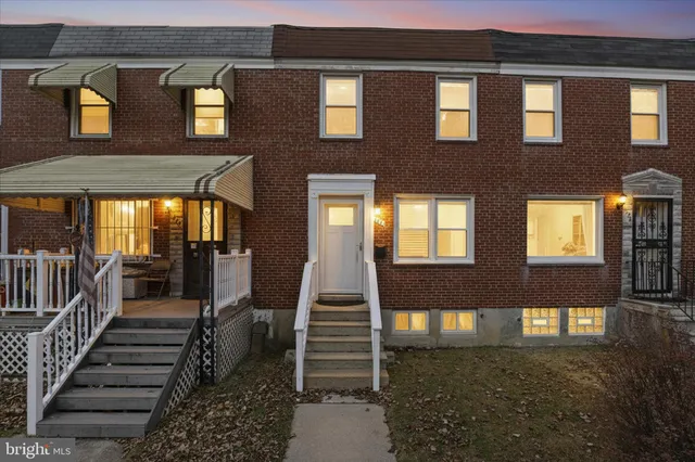 a view of a brick house with many windows and a tree