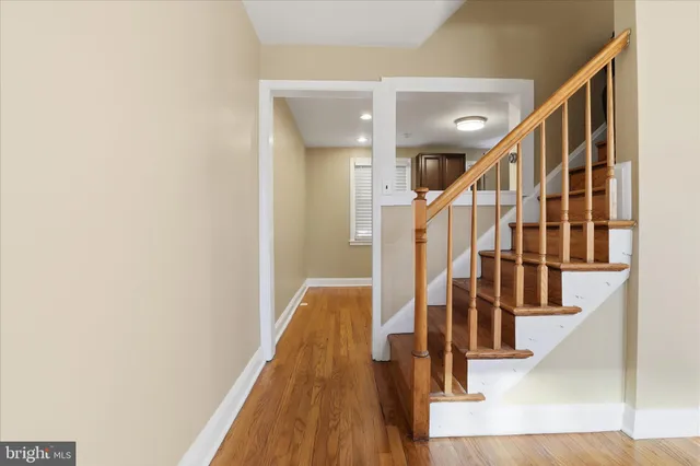 a view of staircase with wooden floor and a chandelier