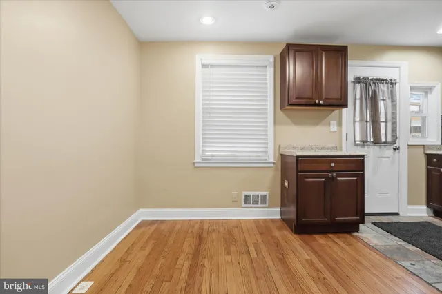 a view of a kitchen with wooden floor and electronic appliances