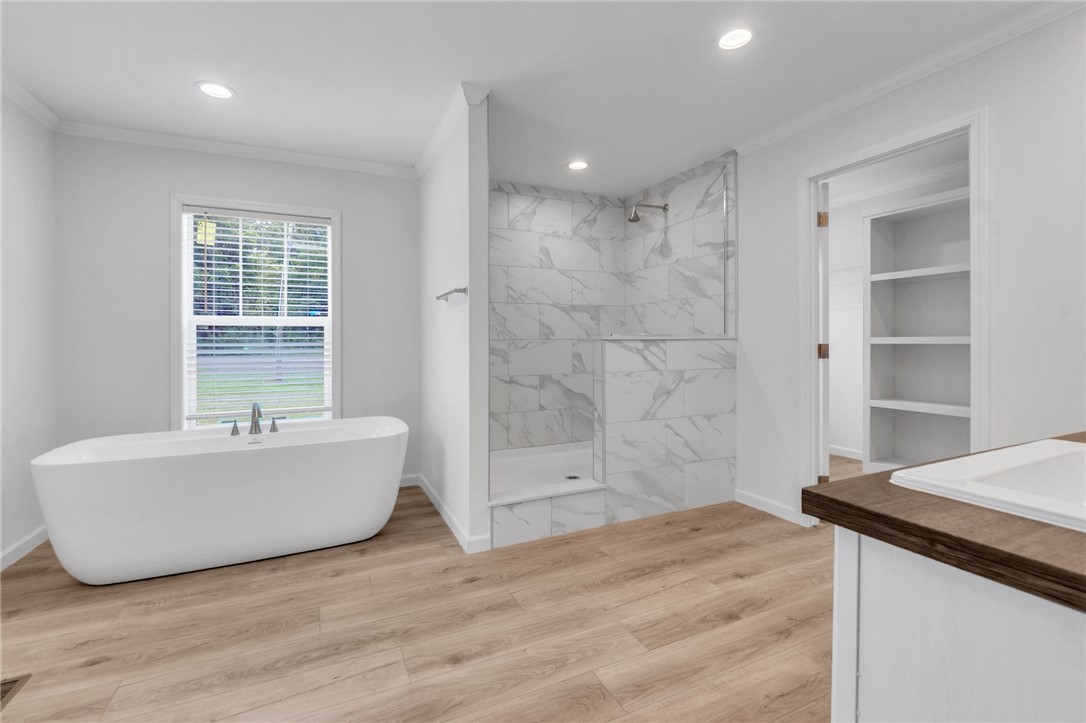 108 Old River Road Iva, SC 29655 - Photo 14 of 31 A spacious primary bathroom boasts a freestanding soaking tub and a sleek, tiled walk-in shower.
