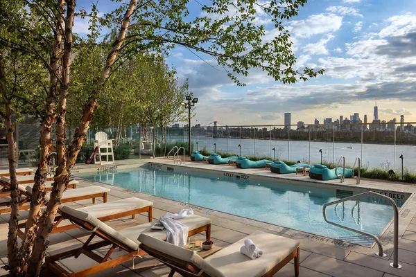 a view of a swimming pool with a patio and a yard