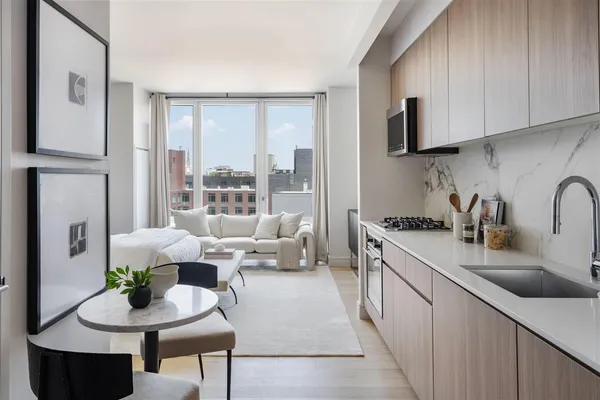a kitchen with stainless steel appliances granite countertop a sink a stove and a refrigerator with wooden floor