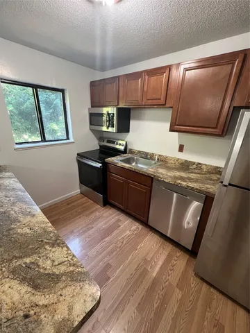 a kitchen with stainless steel appliances granite countertop a stove a sink and a microwave