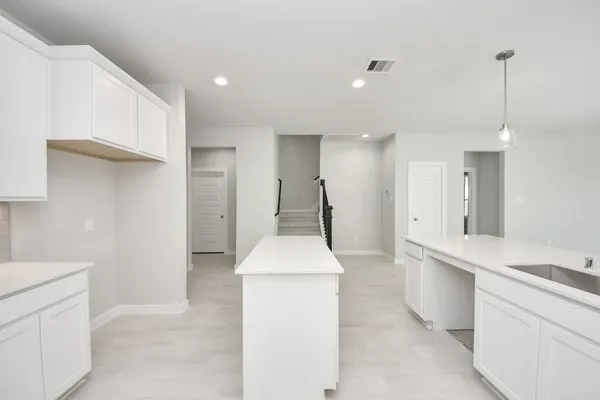 a kitchen with counter top space sink stove and refrigerator