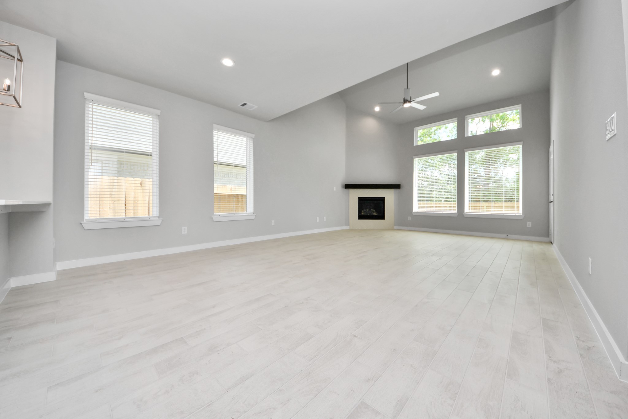 2946 Burris Park Drive Spring, TX 77373 - Photo 18 of 45 Welcome family and guests to your charming living room! With its high ceilings, recessed lighting, ceiling fan, custom paint, beautiful flooring, and large windows that let in abundant natural light, this room is perfect for gatherings.