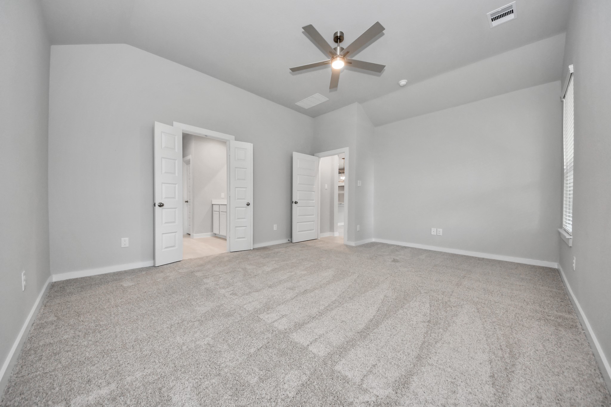 2946 Burris Park Drive Spring, TX 77373 - Photo 24 of 45 Escape and relax in the exquisite primary suite, a haven to unwind after a long day. The spacious room, located on first floor, boasts plush carpeting, soothing paint tones, high ceilings, and expansive windows adorned with privacy blinds.