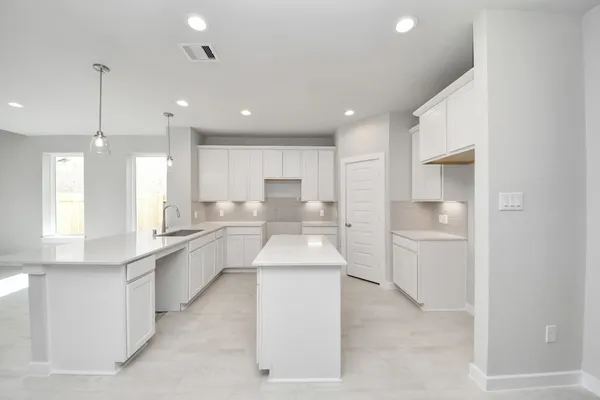 a view of a kitchen with kitchen island a sink stainless steel appliances and cabinets