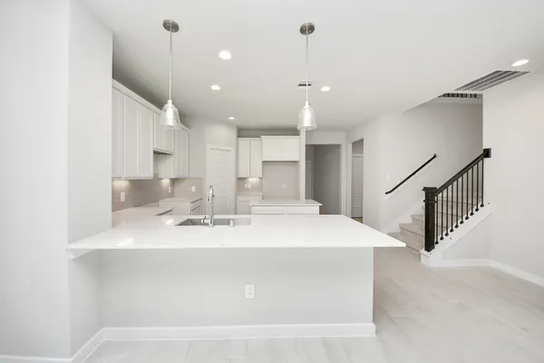 a kitchen with kitchen island a sink stainless steel appliances and white cabinets