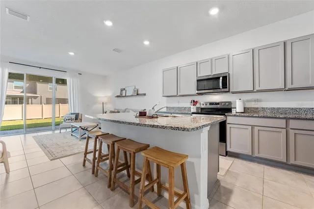 a kitchen with stainless steel appliances granite countertop a stove a sink a microwave and a refrigerator