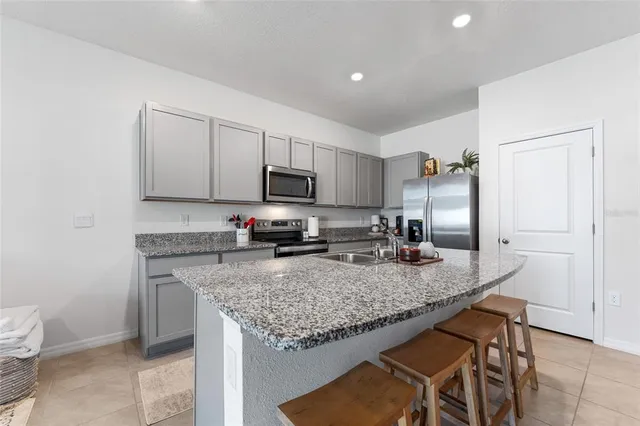 a kitchen with granite countertop a sink counter and chairs