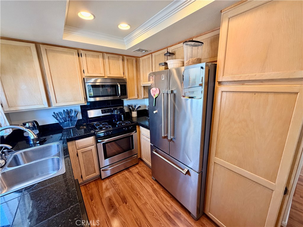 19804 Sandpiper Place, Unit 9 Newhall, CA 91321 - Photo 9 of 27 a kitchen with stainless steel appliances a refrigerator sink and microwave